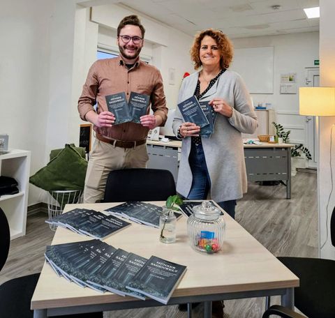 Zwei Menschen präsentieren ein Buch