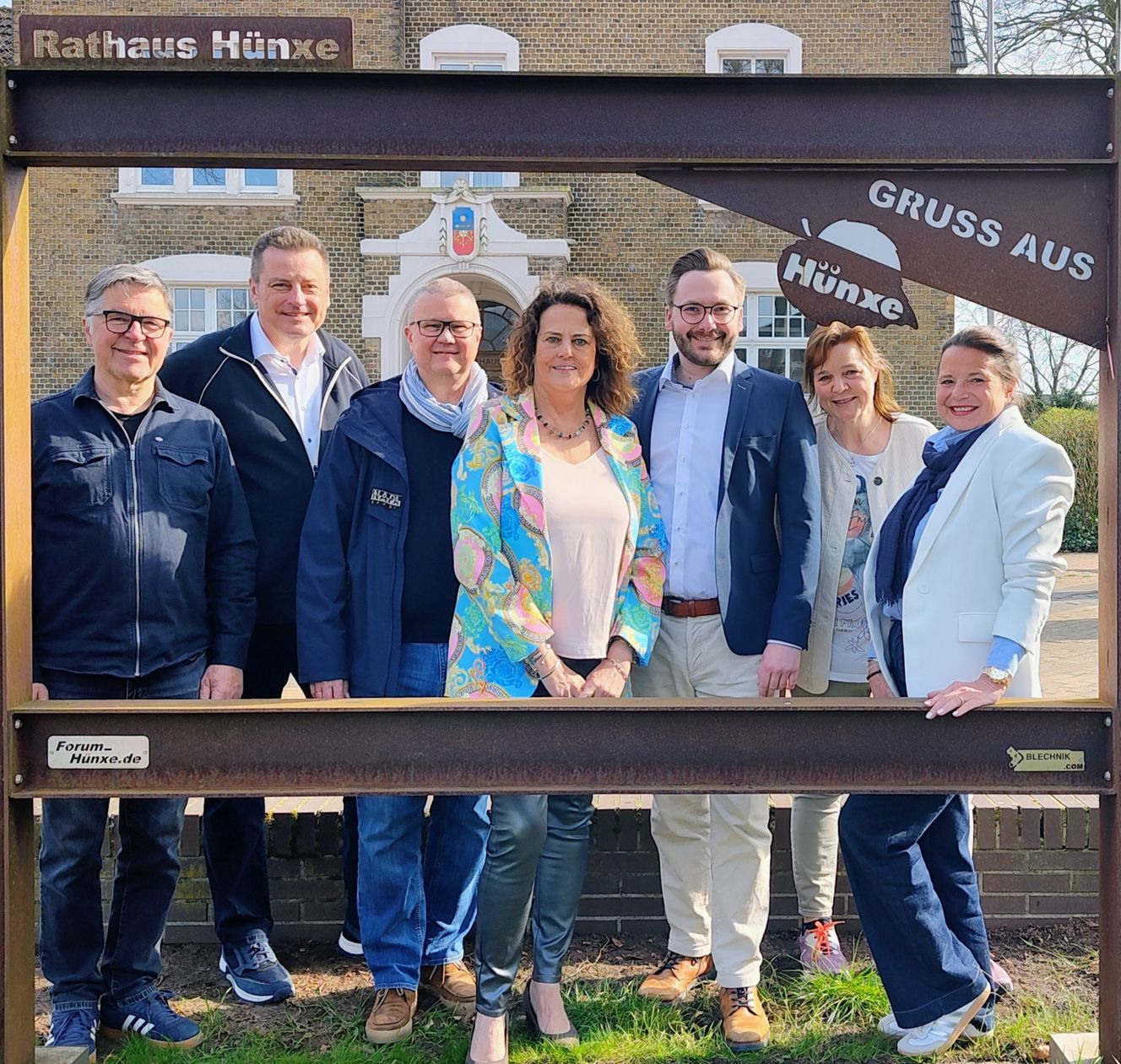 Menschen stehen im sog. Lieblingsrahmen vor dem Rathaus Hünxe