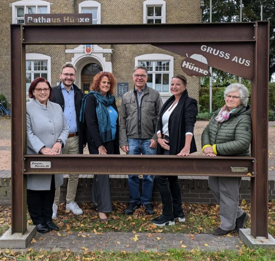 Menschen stehen im sog. Lieblingsrahmen vor dem Rathaus Hünxe